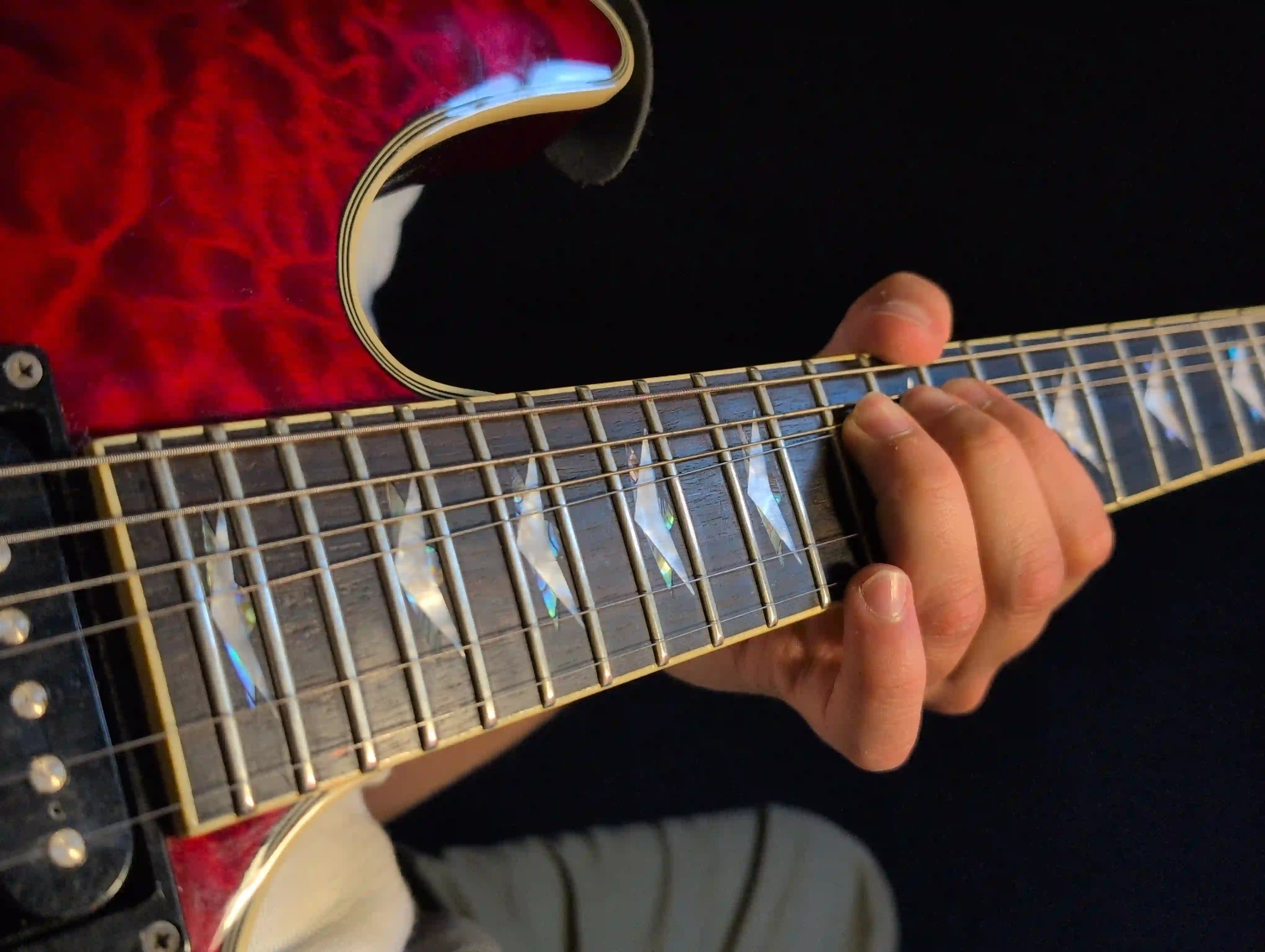 Close-up of hands playing electric guitar scales