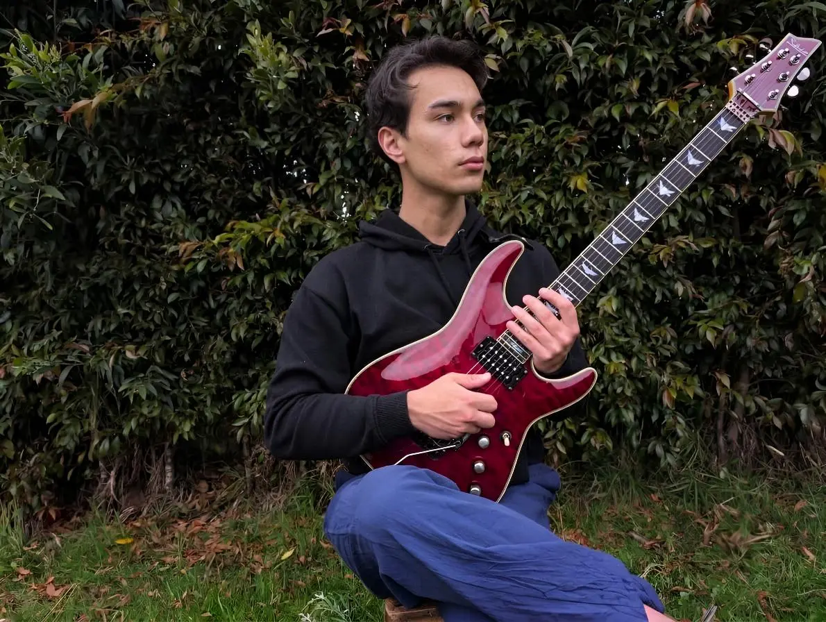 Young musician playing electric guitar outdoors